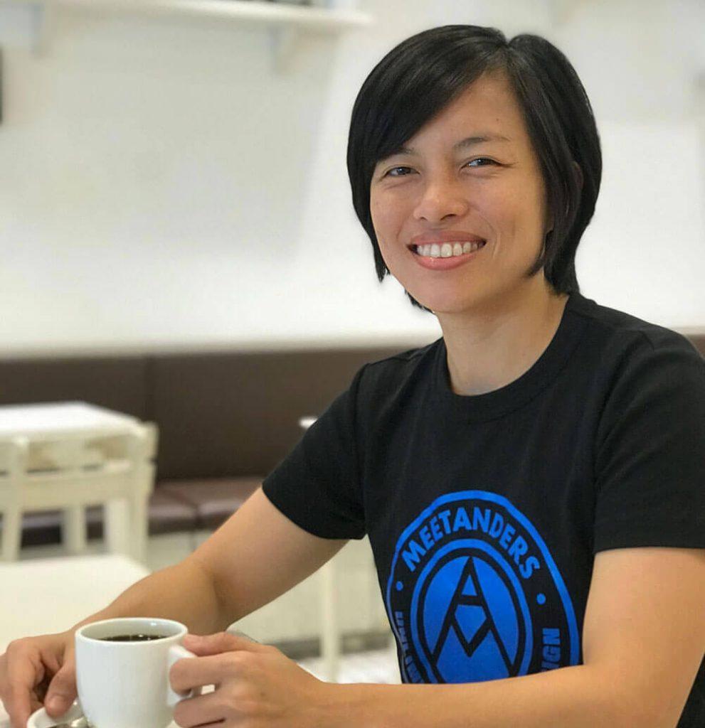 Marilyn Wo of funnel graphic sitting in a coffee shop having a cup of coffee