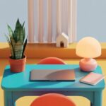 A modern workstation with a blue desk holds a potted plant, colorful lamp, closed laptop, and notebook, creating a vibrant, minimalist setup.