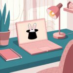 A cozy workspace featuring a laptop with bunny ears in a hat, pink lamp, notebook, and plant on a teal desk.