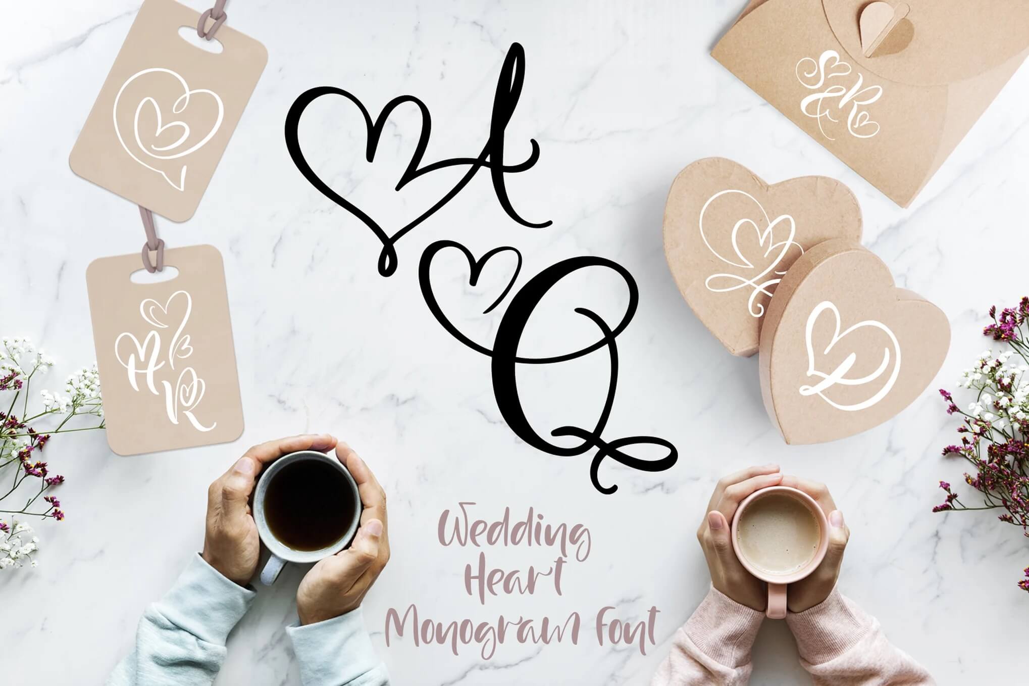 Two people hold coffee cups on a marble surface with heart monograms, tags, and floral accents, showcasing "Wedding Heart Monogram Font."