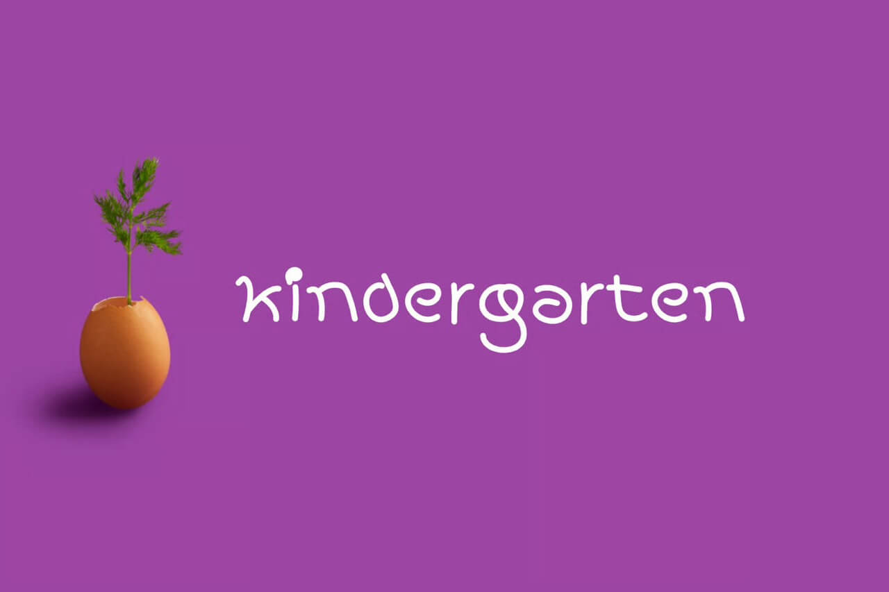A small plant grows from an eggshell on a purple background with "kindergarten" written in white playful font.