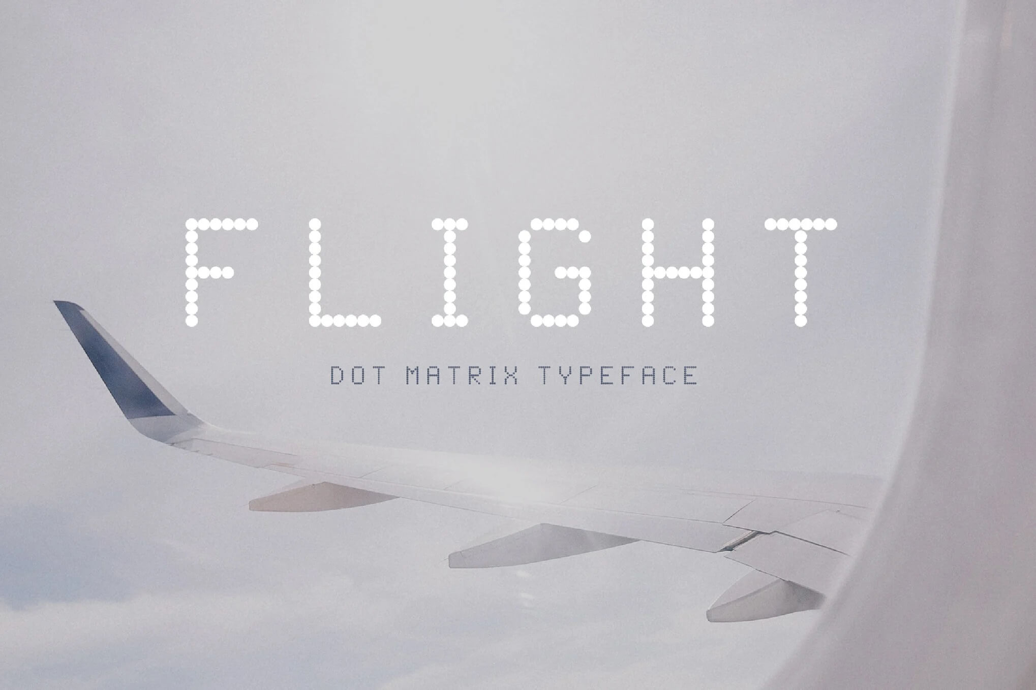 Airplane wing viewed from a window, cloudy sky background. Text "FLIGHT" in dot matrix typeface overlays the scene, emphasizing travel theme.