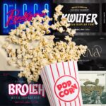 Popcorn spilling from a striped container against a backdrop of various cinematic-themed font posters, featuring bold and artistic text designs.